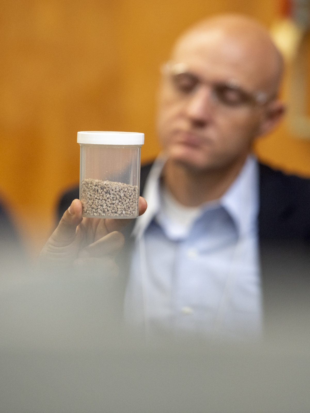 Man holding jar with CNF wood pellets