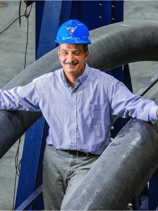 ASCC Executive Director, Dr. Habib Dagher posing between two inflatable composite-concrete arches.
